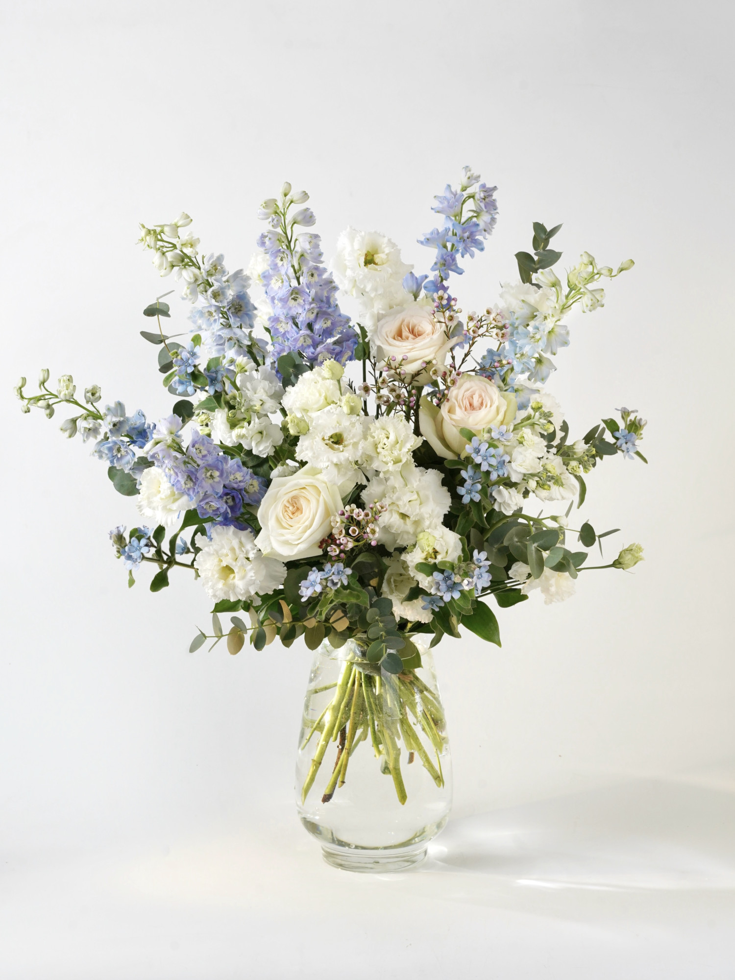 Небесно-голубой букет «Ален» с дельфиниумами и садовыми розами от 10 000 руб. фото 1 &mdash; Городской букет